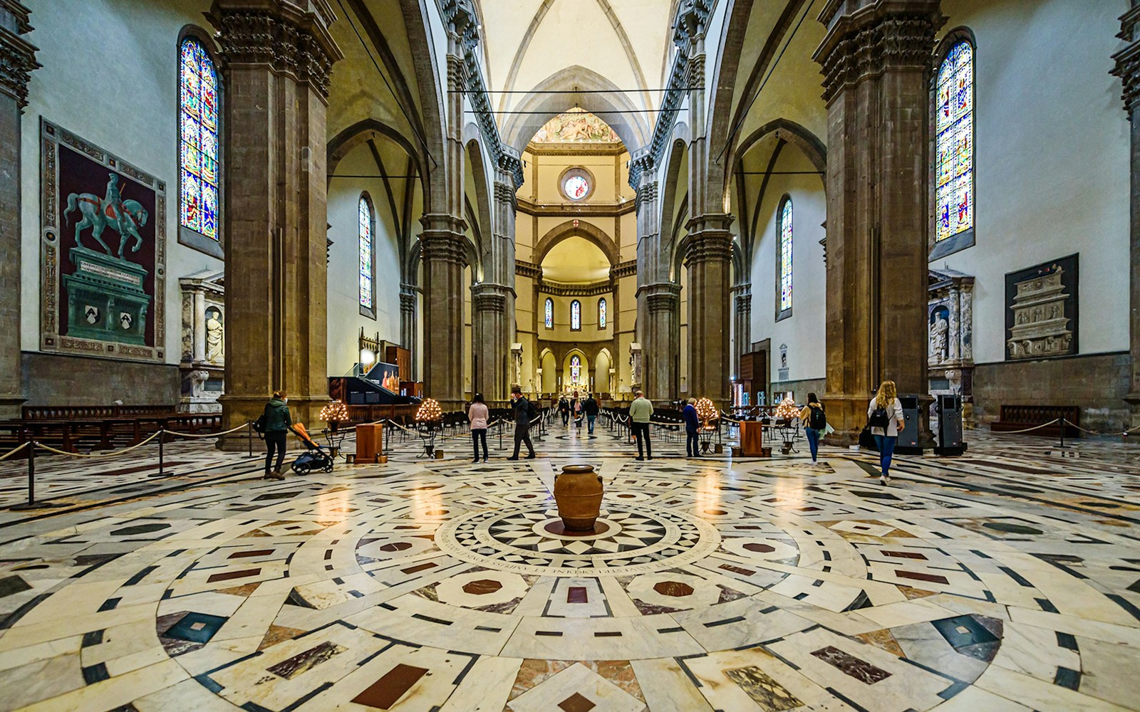 Interior view of Florence Cathedral with ornate marble floor and stained glass windows.