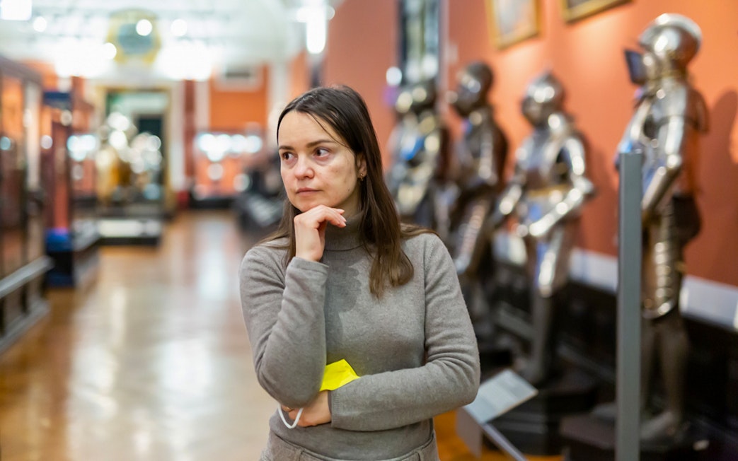 Guest observing armor exhibits inside Kunsthistorisches Museum Vienna.
