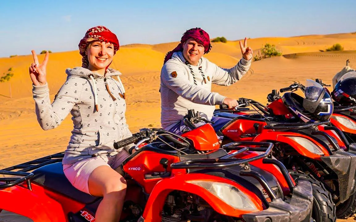 Quad biking in Dubai desert with two people enjoying the safari experience.