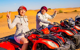 Quad biking in Dubai desert with two people enjoying the safari experience.