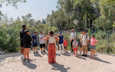 Tour guide leading a group at Duden Waterfalls, surrounded by lush greenery.