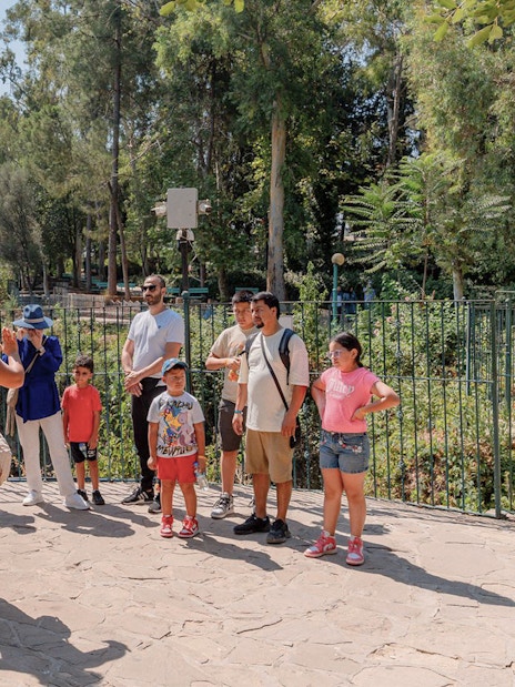 Tour guide leading a group at Duden Waterfalls, surrounded by lush greenery.