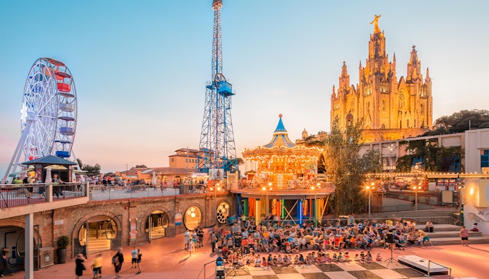 Visitors enjoying rides at Tibidabo Amusement Park in Barcelona.