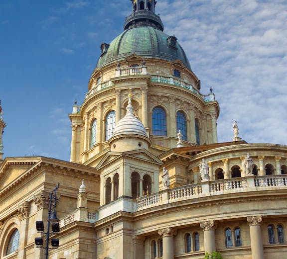 St. Stephen's Basilica dome in Budapest, Hungary, under a blue sky.