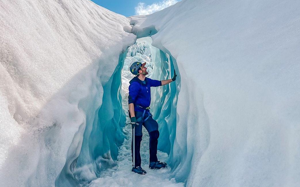 Person exploring ice cave during Vatnajökull glacier expedition.