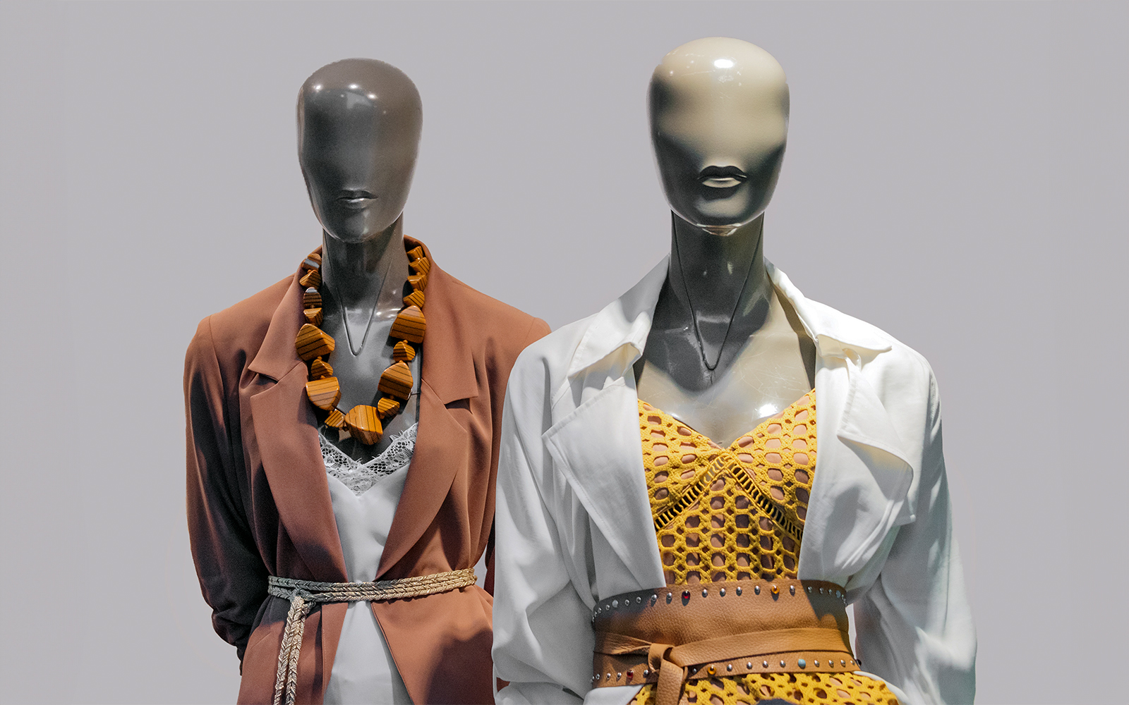 Mannequins in fashion museum displaying vintage clothing and accessories.