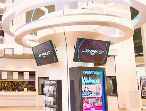 Joypolis information kiosk with digital screens in a modern indoor setting.
