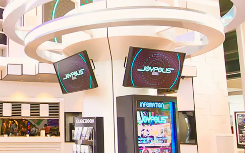 Joypolis information kiosk with digital screens in a modern indoor setting.