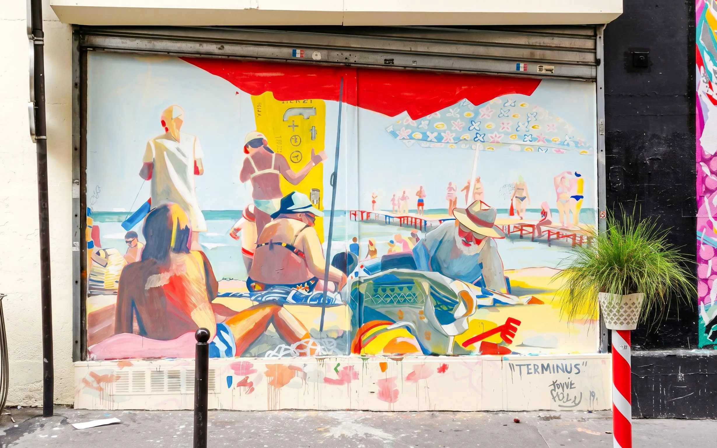 Street art mural depicting a vibrant beach scene in Montmartre, Paris.