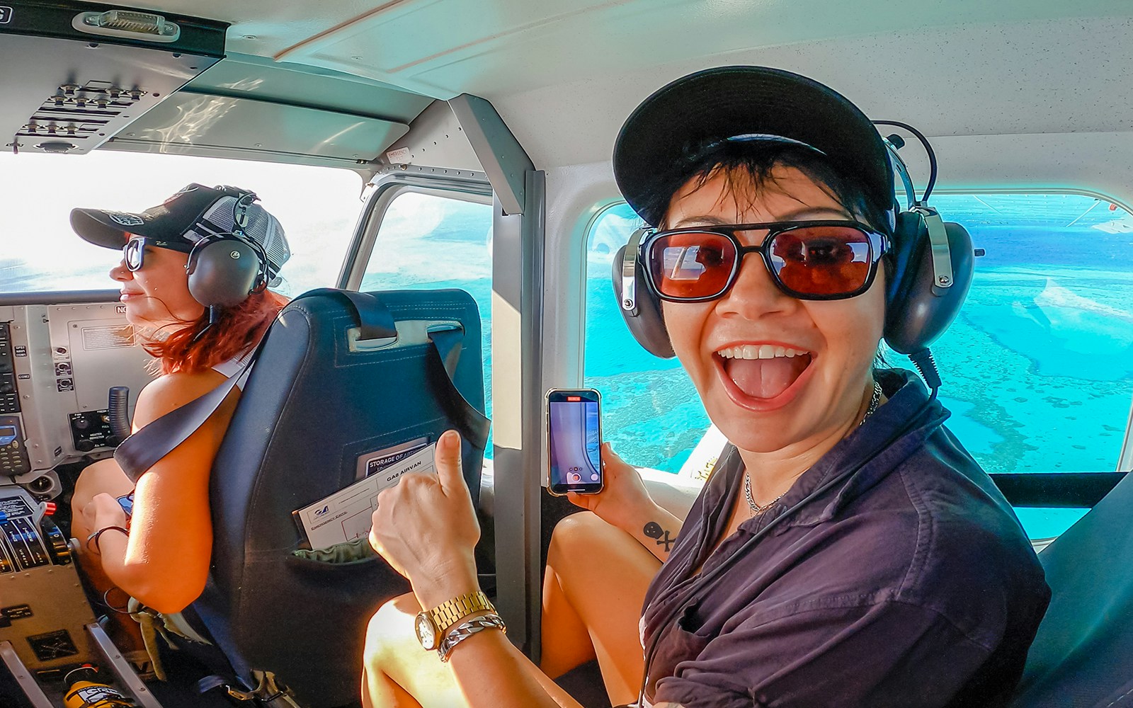 Scenic flight over Whitsundays with passengers enjoying aerial views of turquoise waters.