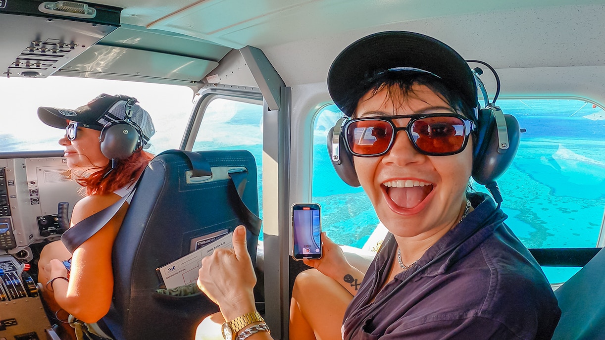 Scenic flight over Whitsundays with passengers enjoying aerial views of turquoise waters.