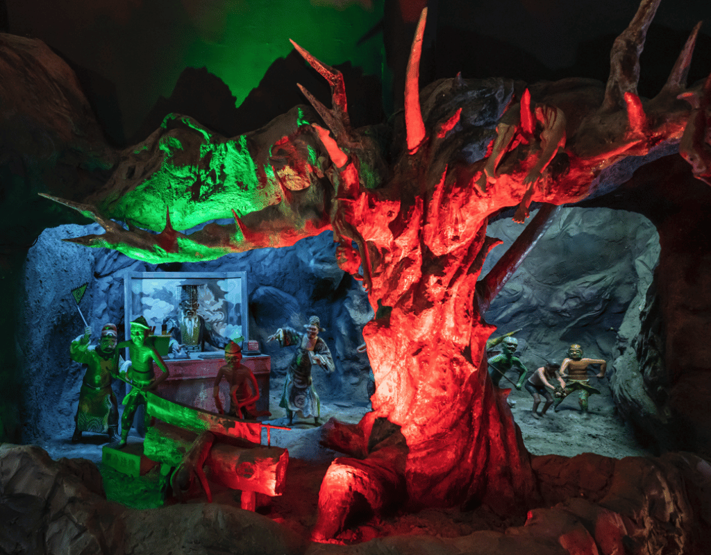 Diorama of underworld judgment scenes at Hell's Museum with vivid lighting effects.