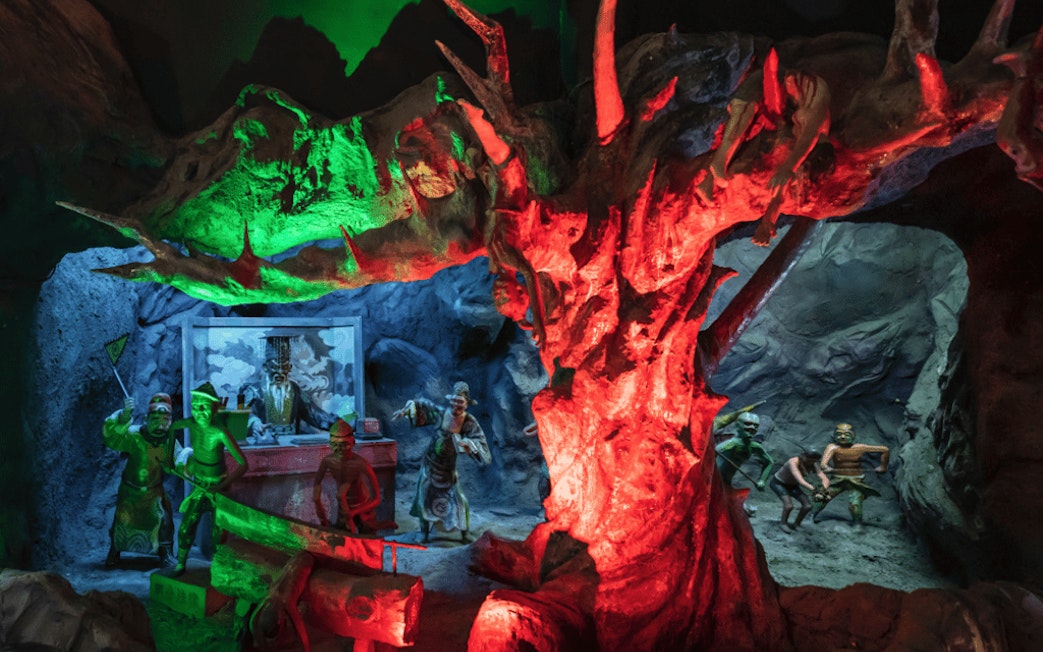 Diorama of underworld judgment scenes at Hell's Museum with vivid lighting effects.