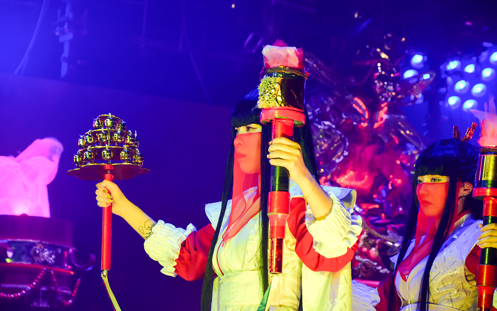 Performer holding props at Samurai Restaurant Show in vibrant lighting.