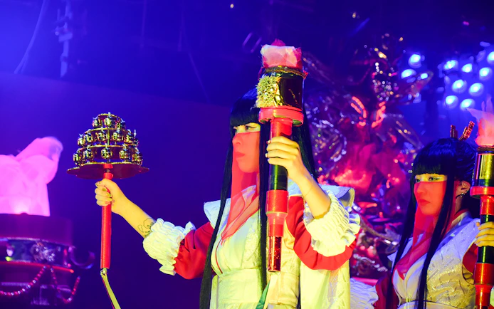 Performer holding props at Samurai Restaurant Show in vibrant lighting.