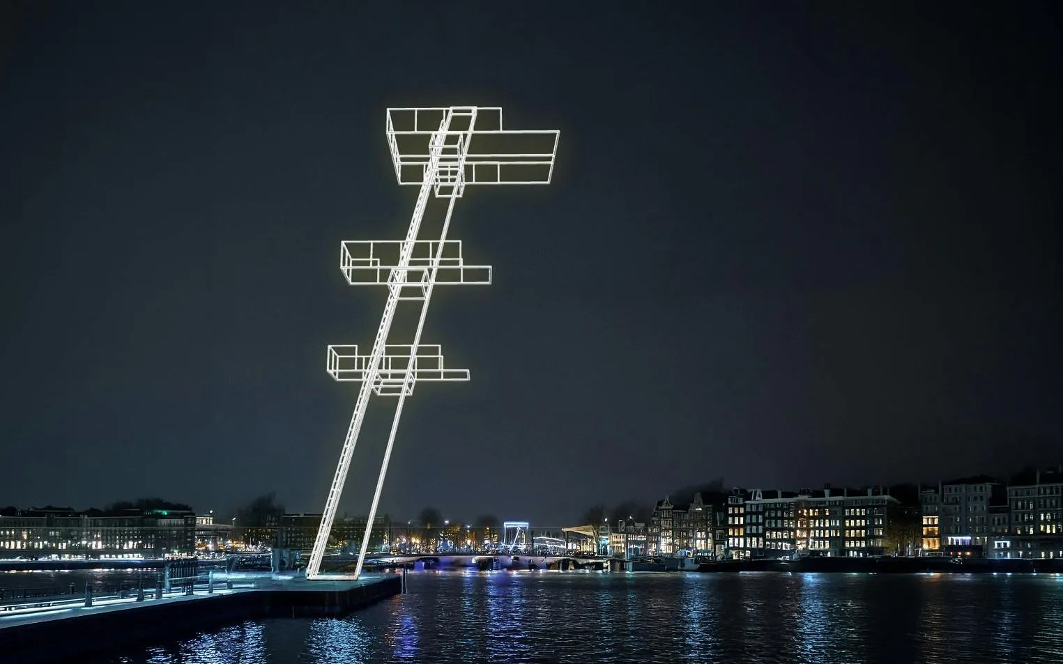 Illuminated art installation over canal during Amsterdam Light Festival.