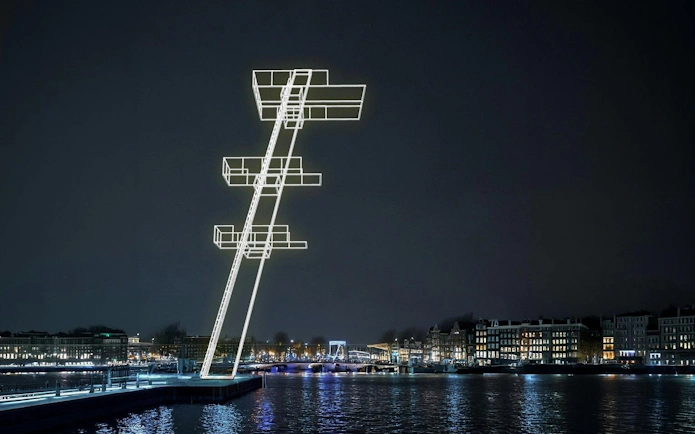 Illuminated art installation over canal during Amsterdam Light Festival.