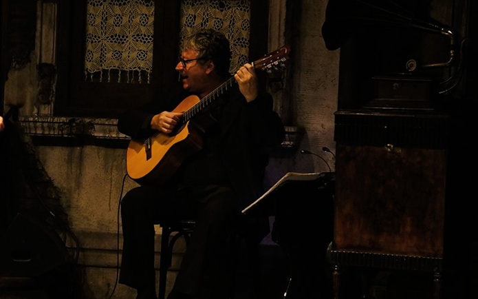 Guitarist performing at Aljibe Tango Show in Buenos Aires.