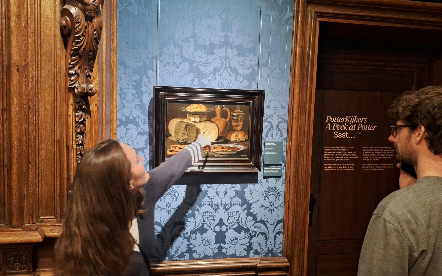 Visitor pointing at a still life painting in the Mauritshuis museum.