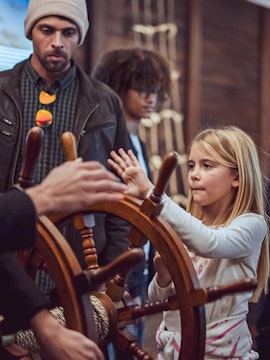 Child steering ship wheel during Porto Region Across the Ages tour.