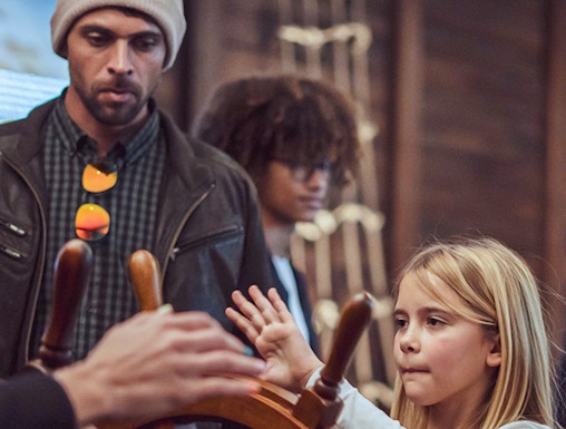 Child steering ship wheel during Porto Region Across the Ages tour.