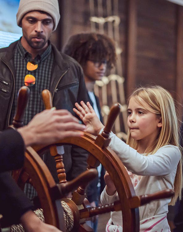 Child steering ship wheel during Porto Region Across the Ages tour.