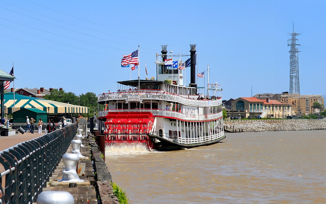 People walking toward Steamboat Natchez docked in the French Quarter, New Orleans.