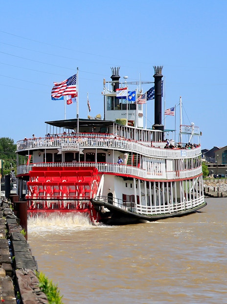 People walking toward Steamboat Natchez docked in the French Quarter, New Orleans.