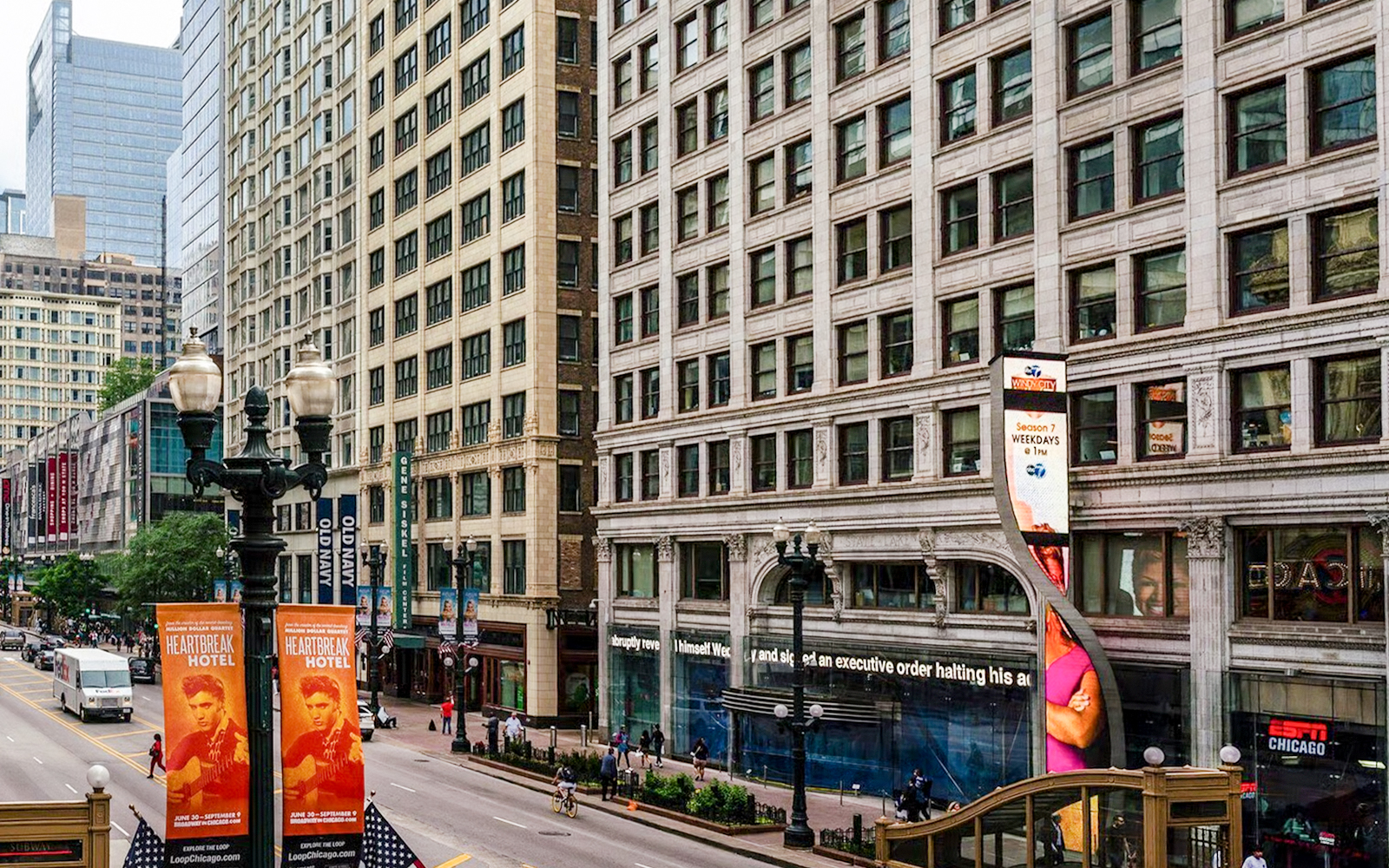 Street view of ABC Building in Chicago with pedestrians and nearby shops.