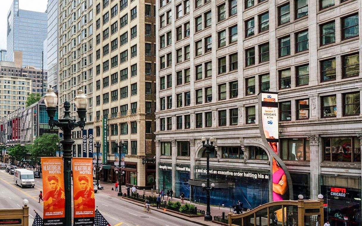Street view of ABC Building in Chicago with pedestrians and nearby shops.