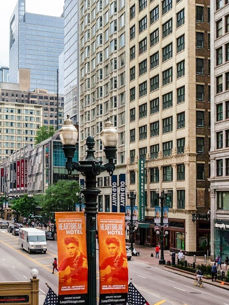 Street view of ABC Building in Chicago with pedestrians and nearby shops.