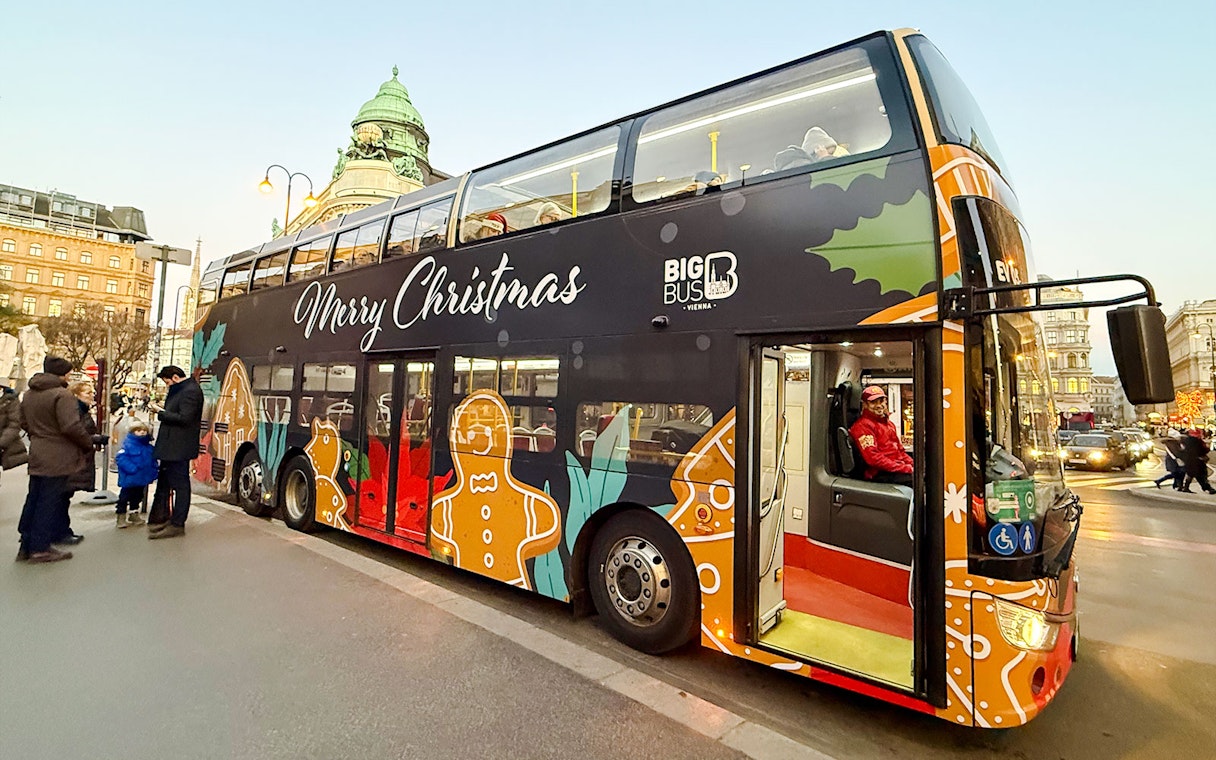 Big Bus HOHO Christmas-themed bus in front of Generali building, Vienna, Austria.
