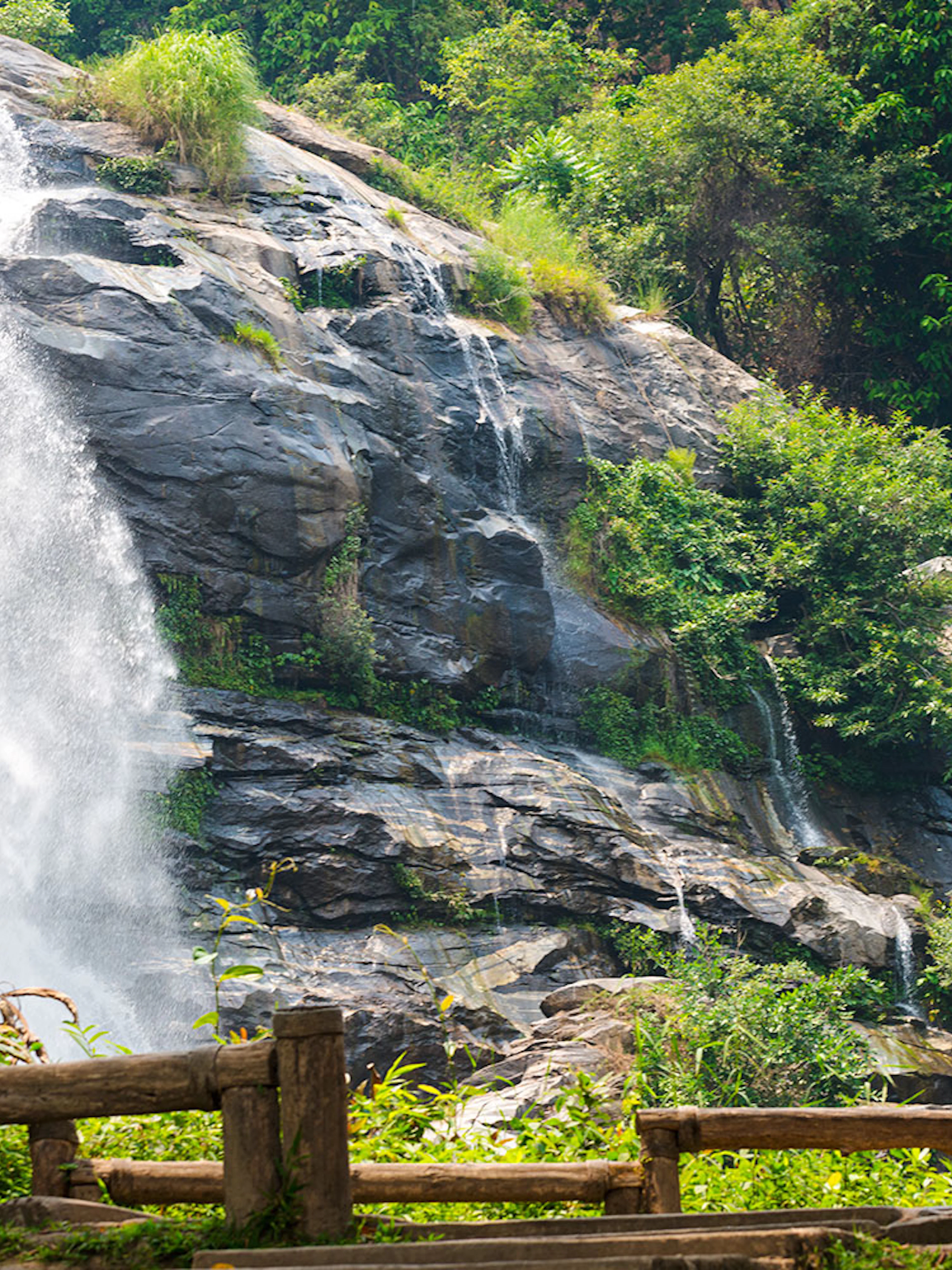Waterfall at Doi Inthanon with a visitor taking photos, Chiang Mai Elephant Sanctuary tour.