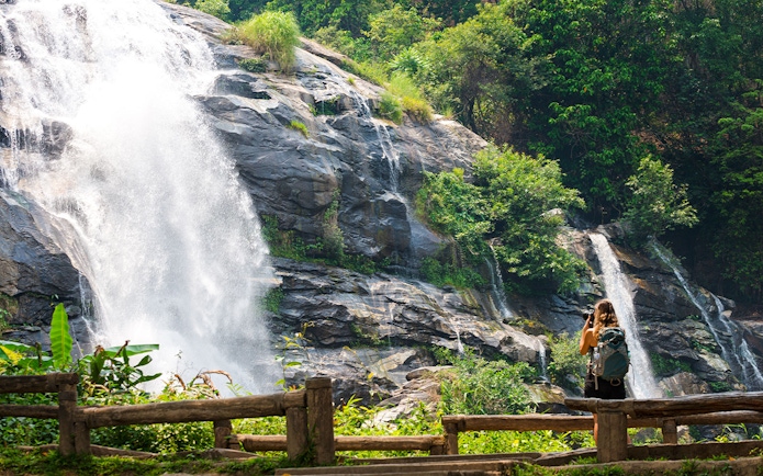 Waterfall at Doi Inthanon with a visitor taking photos, Chiang Mai Elephant Sanctuary tour.