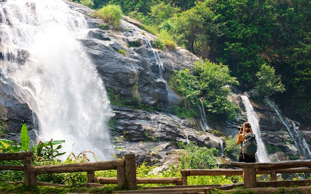 Waterfall at Doi Inthanon with a visitor taking photos, Chiang Mai Elephant Sanctuary tour.