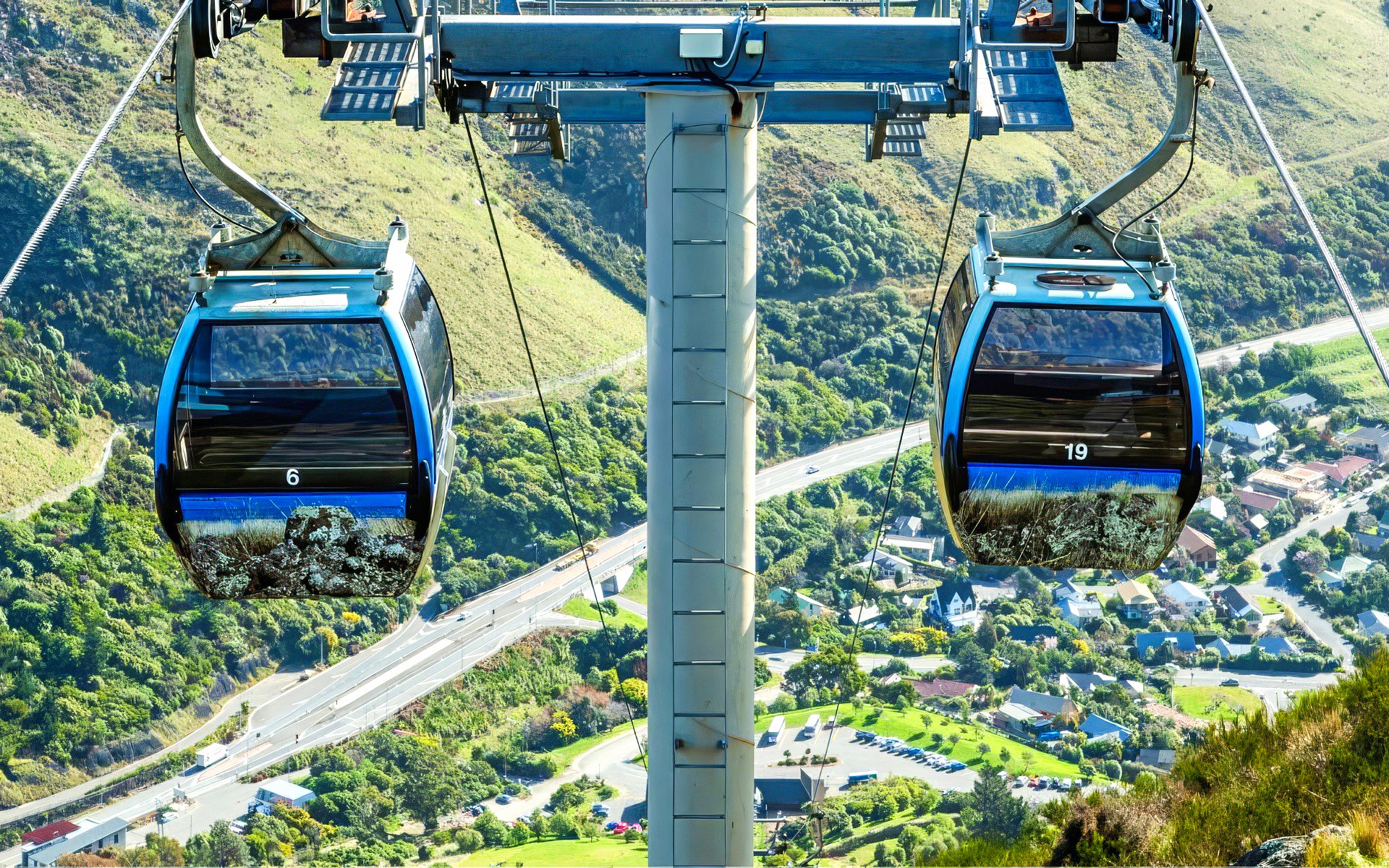Gondola ride over Christchurch landscape with hills and roads below.