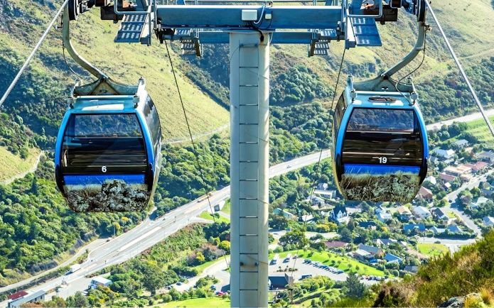Gondola ride over Christchurch landscape with hills and roads below.
