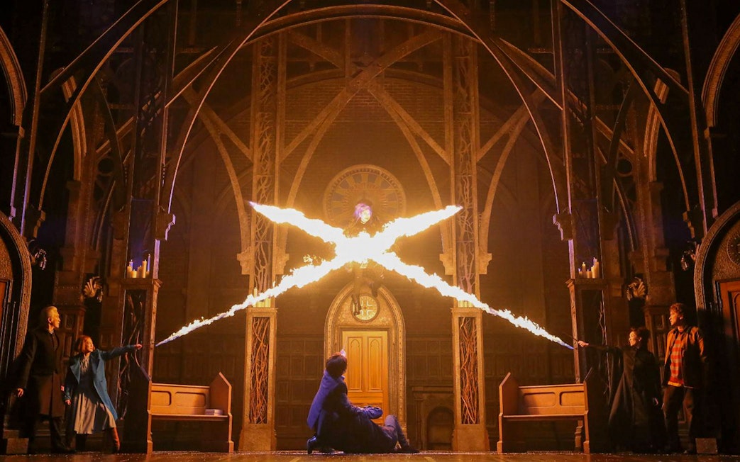 Characters casting spells in a dramatic scene from "Harry Potter and the Cursed Child" play.