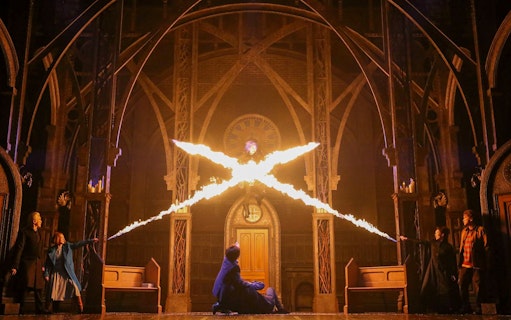 Characters casting spells in a dramatic scene from "Harry Potter and the Cursed Child" play.