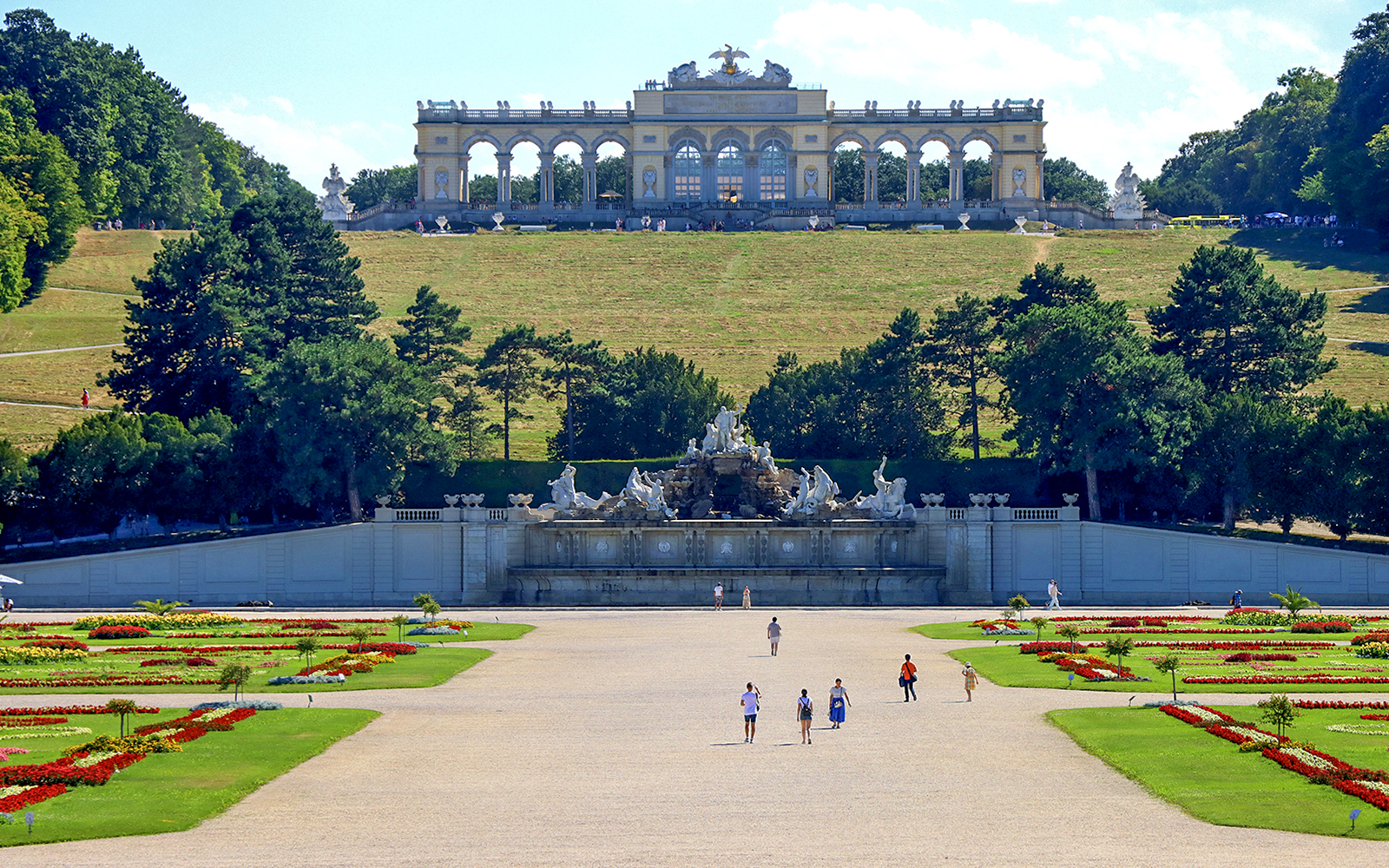 Gloriette pavilion in Schönbrunn garden, Vienna, with visitors and landscaped grounds.
