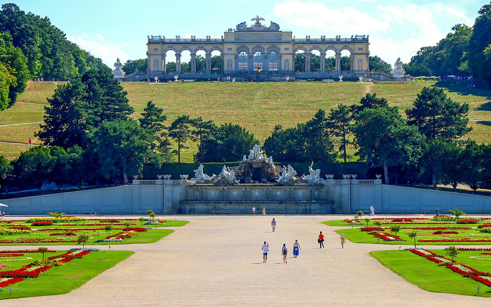 Gloriette pavilion in Schönbrunn garden, Vienna, with visitors and landscaped grounds.