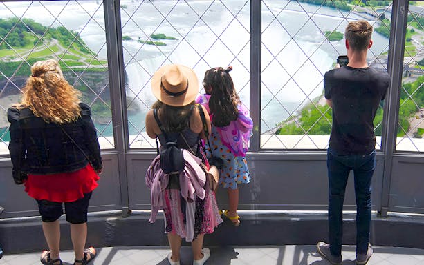 Visitors enjoying Niagara Falls view from Skylon Tower observation deck.