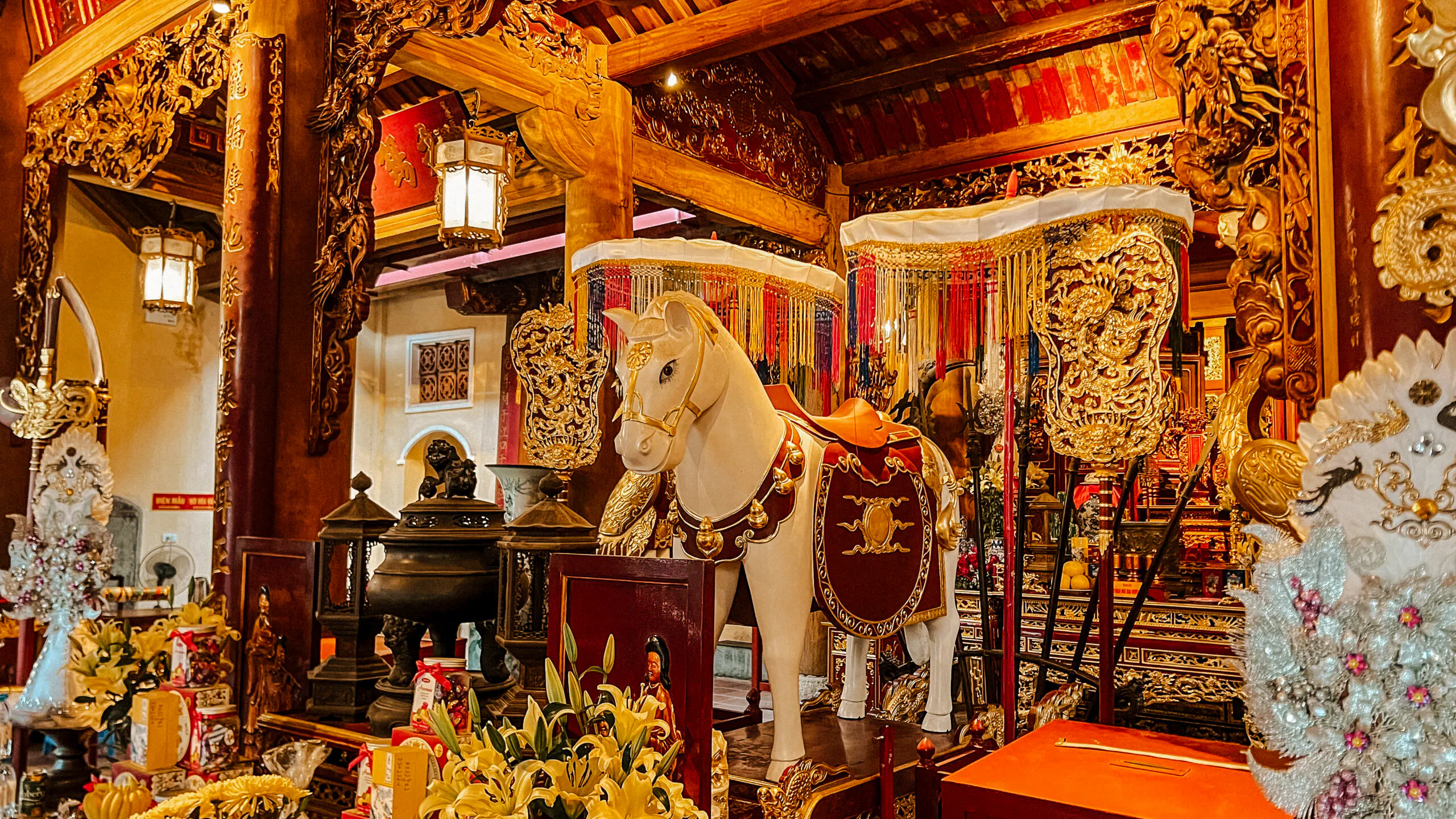 Decorated altar with horse statue in Hanoi's Old Quarter temple.