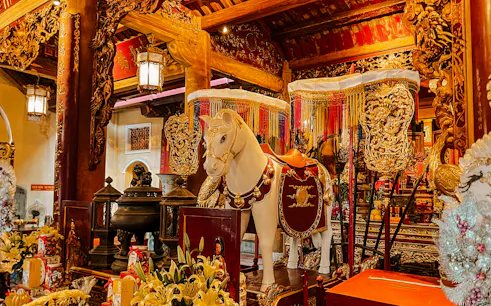 Decorated altar with horse statue in Hanoi's Old Quarter temple.