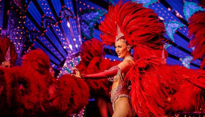 Cabaret performer in red feathers at Moulin Rouge, Paris.