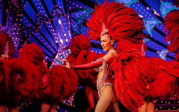 Cabaret performer in red feathers at Moulin Rouge, Paris.