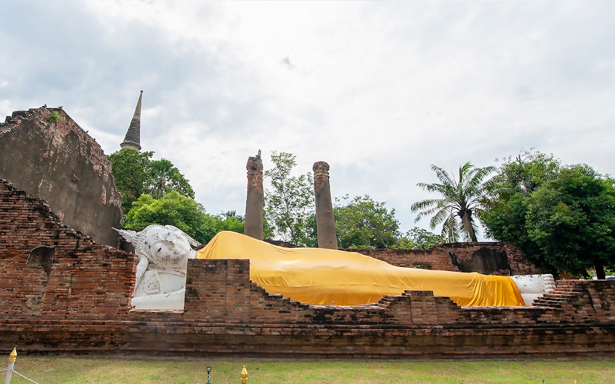 Reclining Buddha statue covered in yellow cloth at Ayutthaya temple, Thailand.