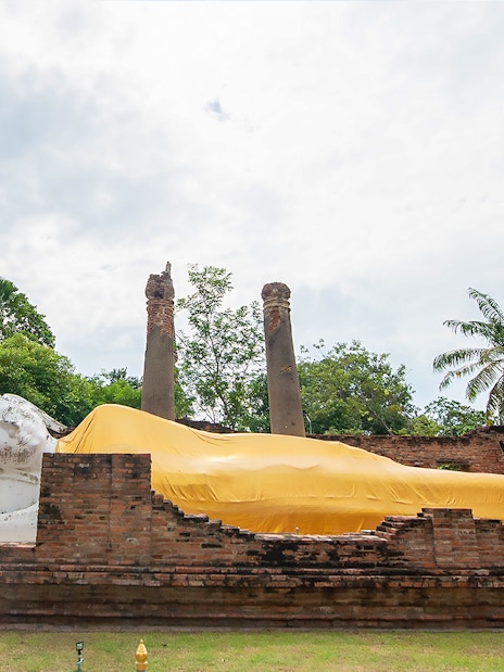 Reclining Buddha statue covered in yellow cloth at Ayutthaya temple, Thailand.