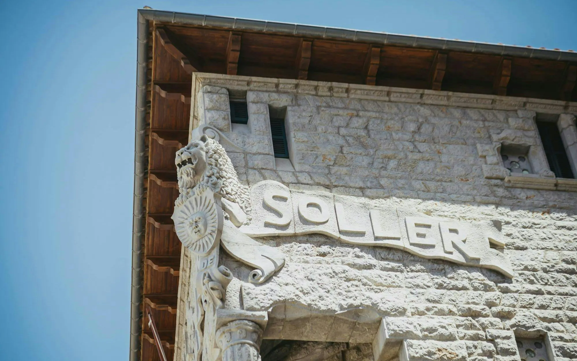 Stone facade with "Soller" sign and lion sculpture in Soller, Mallorca.