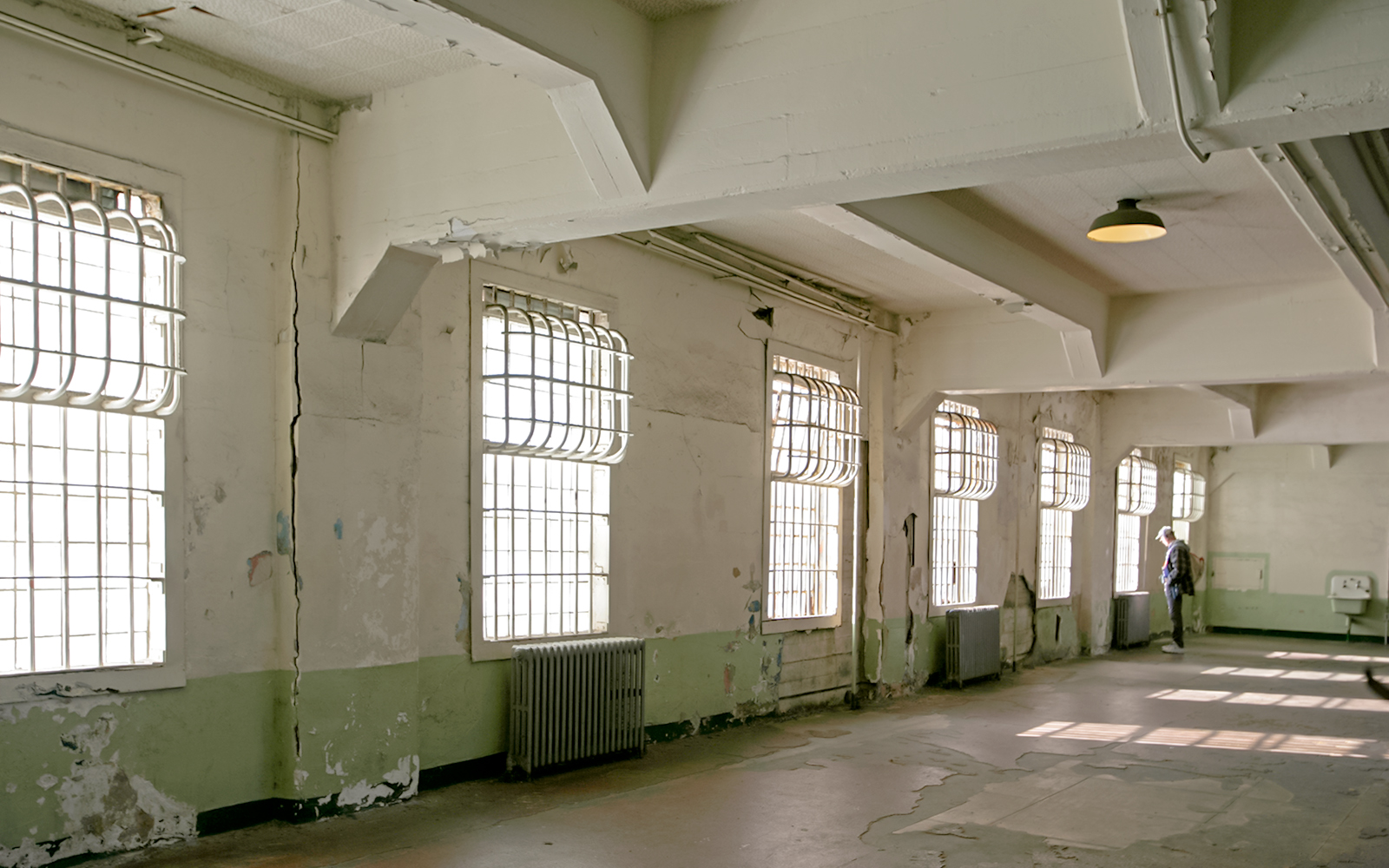 Alcatraz mess hall interior with barred windows and peeling paint.